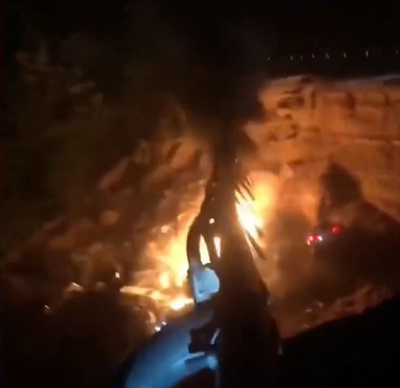 塌陷路段有汽车跌落大坑起火，冒出火光及浓烟。