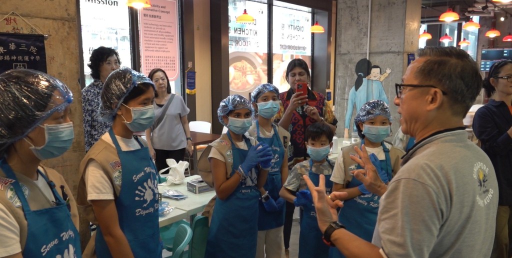 美國海外女童軍香港分支擔當一日「派飯員」，聽從創辦人許承俊介紹，了解殘疾僱員工作能力及派飯緣由。