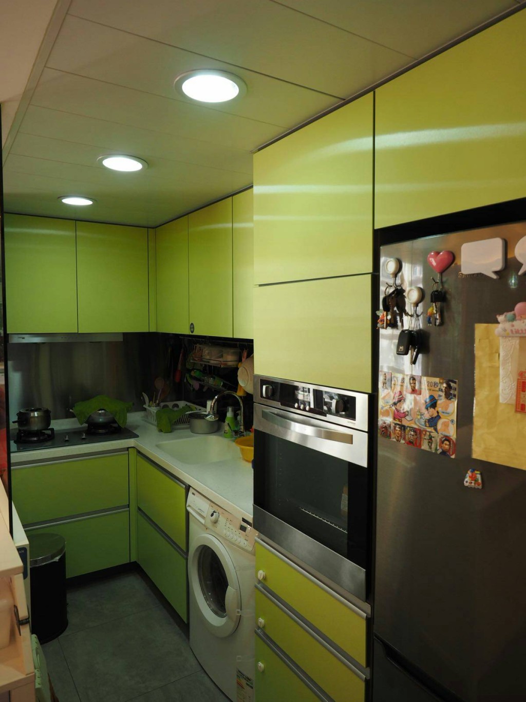 廚房採用半開放式設計，設有組合廚櫃，以青綠色為主調。