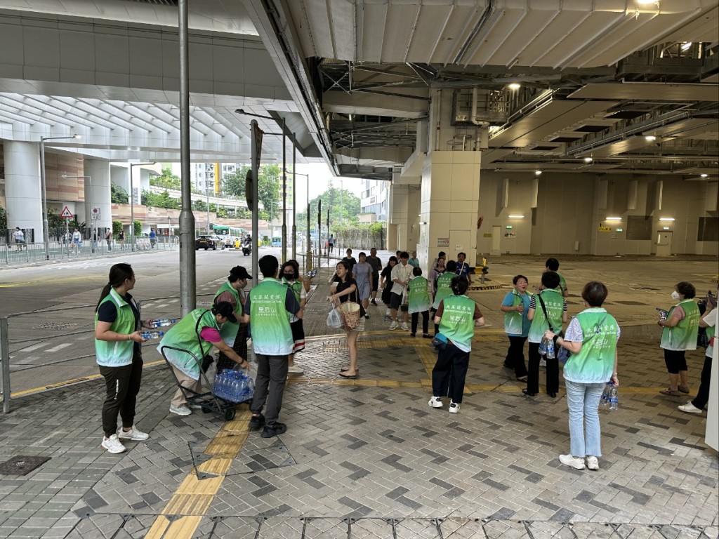 關愛隊在邨內主要通道派水供居民應急。 關愛隊在邨內主要通道派水供居民應急。
