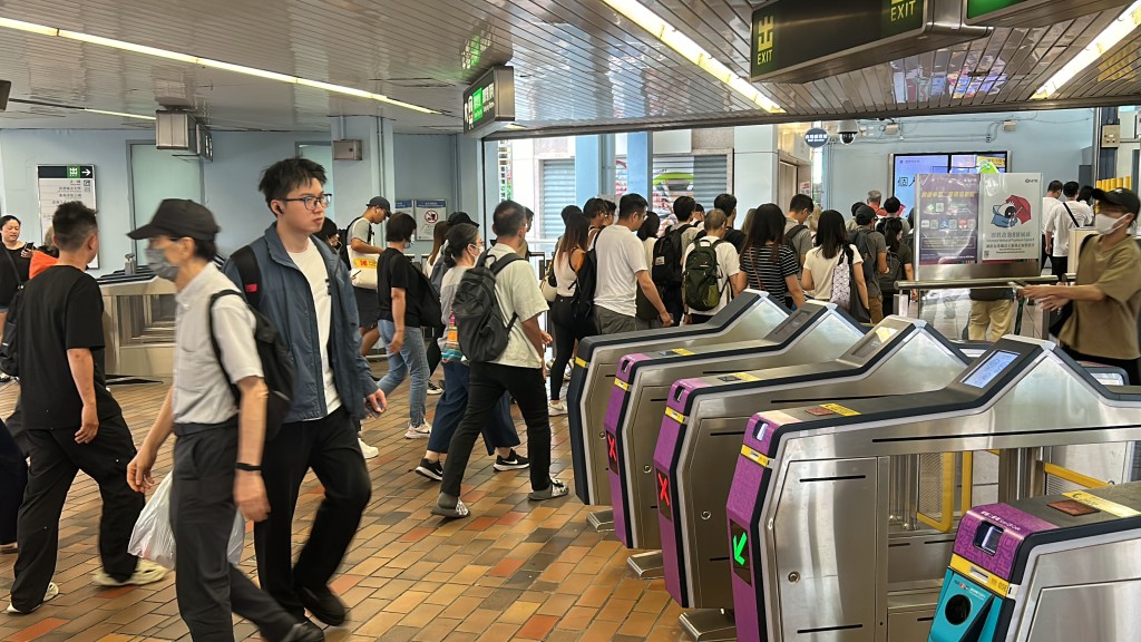 天文台預告掛8號風球，打工仔提早放工，港鐵九龍塘站現人潮。林思明攝
