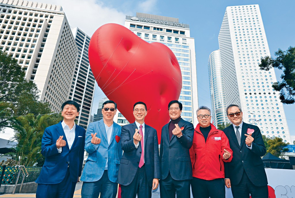 黃偉綸與楊潤雄等嘉賓，在「紅色巨心」前齊舉「心心」手勢留影。