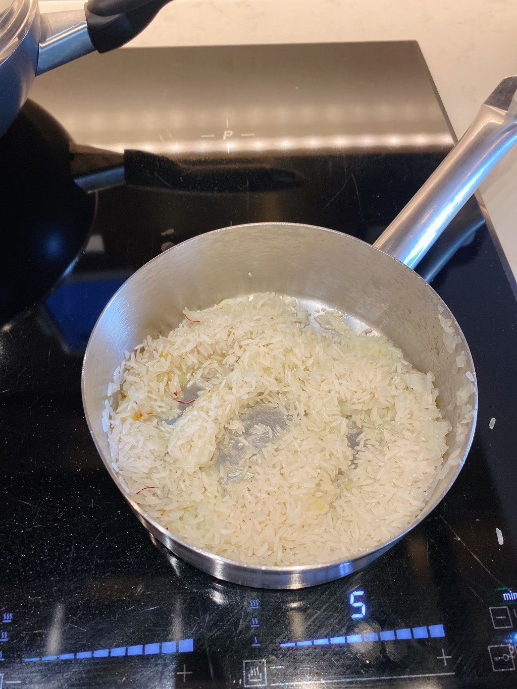 1. 在可入焗爐的小鍋放入橄欖油煎洋葱，加入米和藏紅花。
