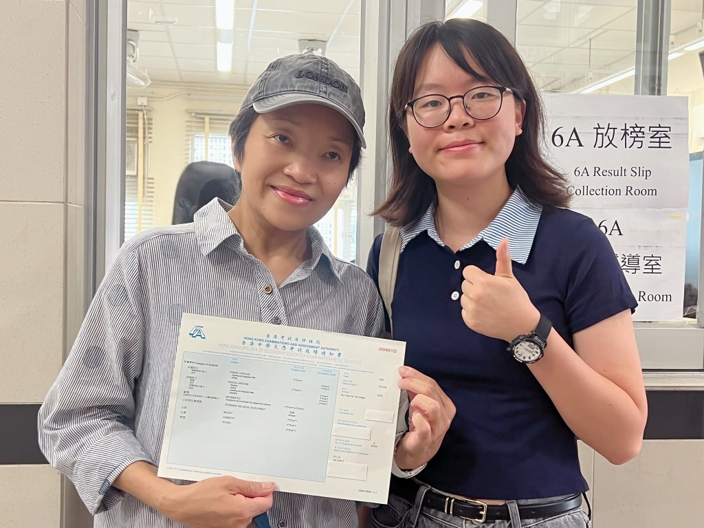保良局董玉娣中学状元李心儿的成绩单今日由其母亲(左)及姐姐代领。 保良局董玉娣中学状元李心儿的成绩单今日由其母亲(左)及姐姐代领。