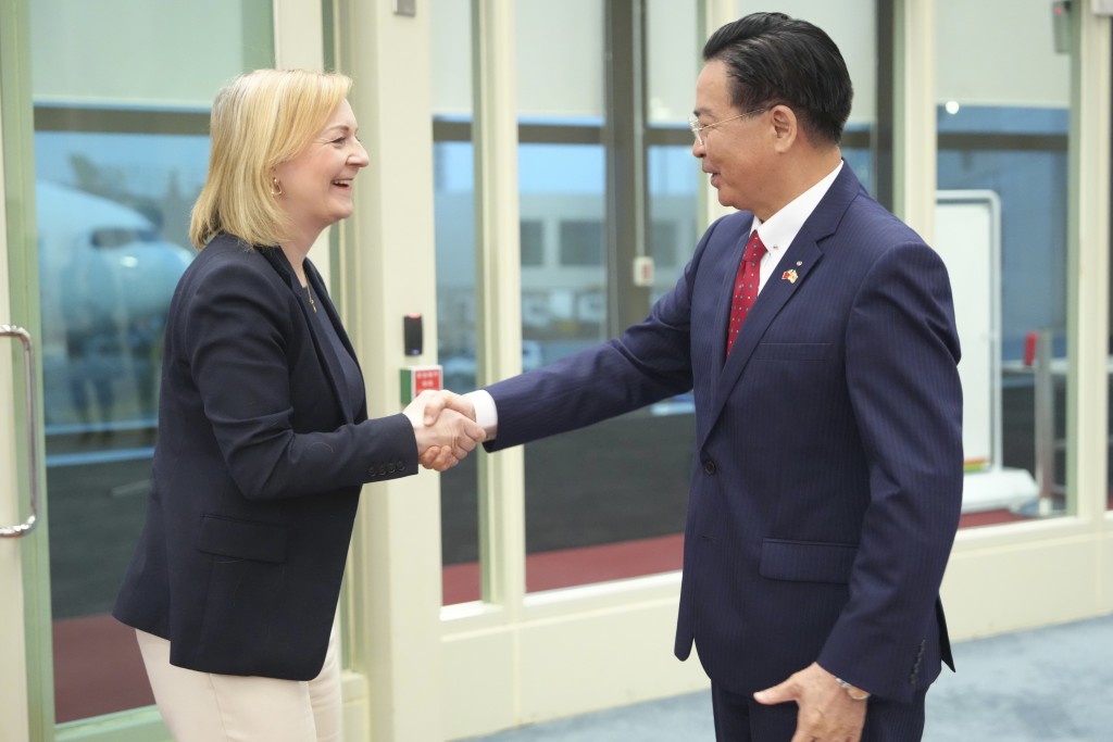 英國前首相卓慧思周二抵達台灣桃園機場時與台灣外交部長吳釗燮握手。AP