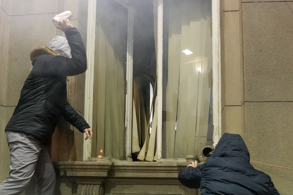 示威者打破市政府大楼的窗户。美联社