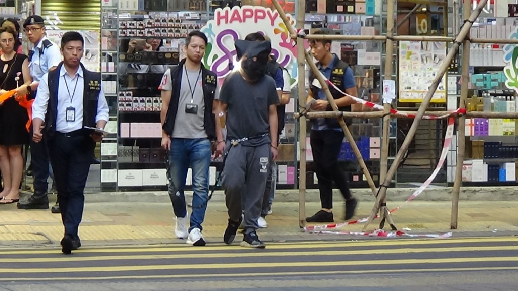 警方押解疑犯過馬路
