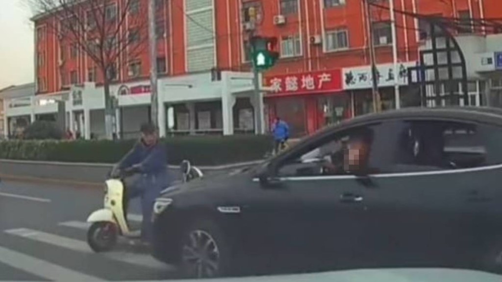黑色車司機不滿女事主停車讓路人，舉中指挑釁，卻撞到一名騎電動車的大叔。