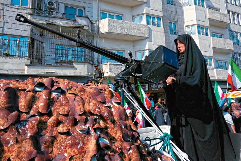 伊朗革命衛隊巴斯基準軍事組織的女成員手持機槍。