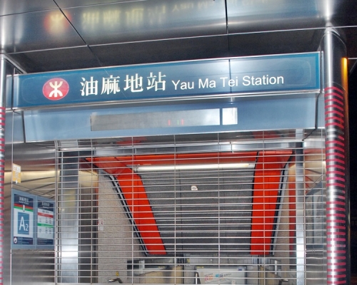 青年以箱頭筆在油麻地站A出口地面出口外牆上寫字。資料圖片