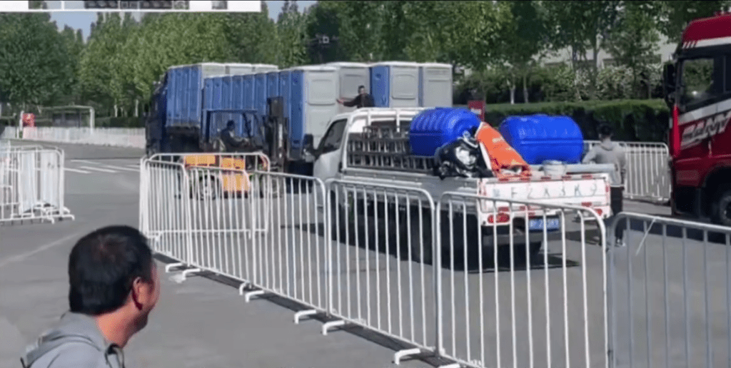 網片顯示,剷車從貨車上將流動厠所運下來。 網片顯示,剷車從貨車上將流動厠所運下來。