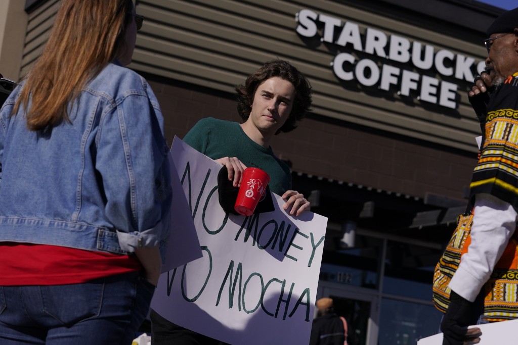  在亚利桑那州梅萨，星巴克罢工的员工，手持红杯及「NO MONEY NO MOCHA」的标语。AP
