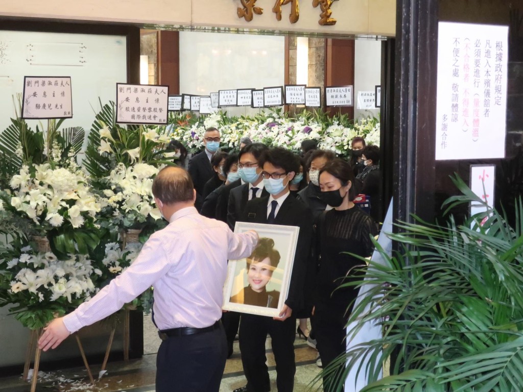 劉健樂捧母遺照送別最後一程。
