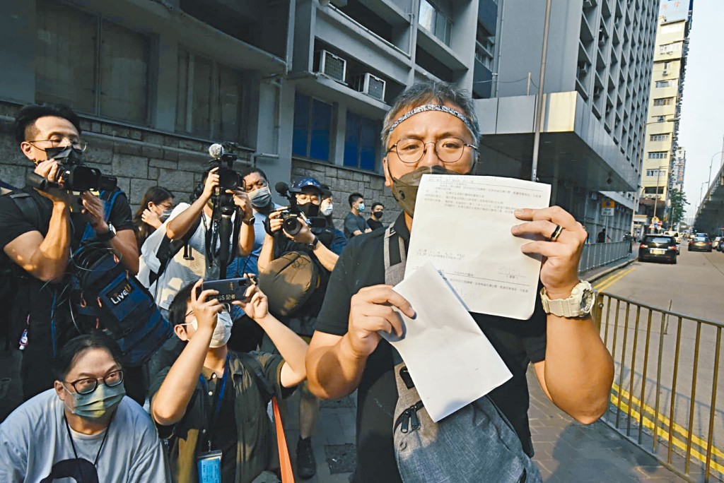 記協主席陳朗昇展示警方發出的控罪書。