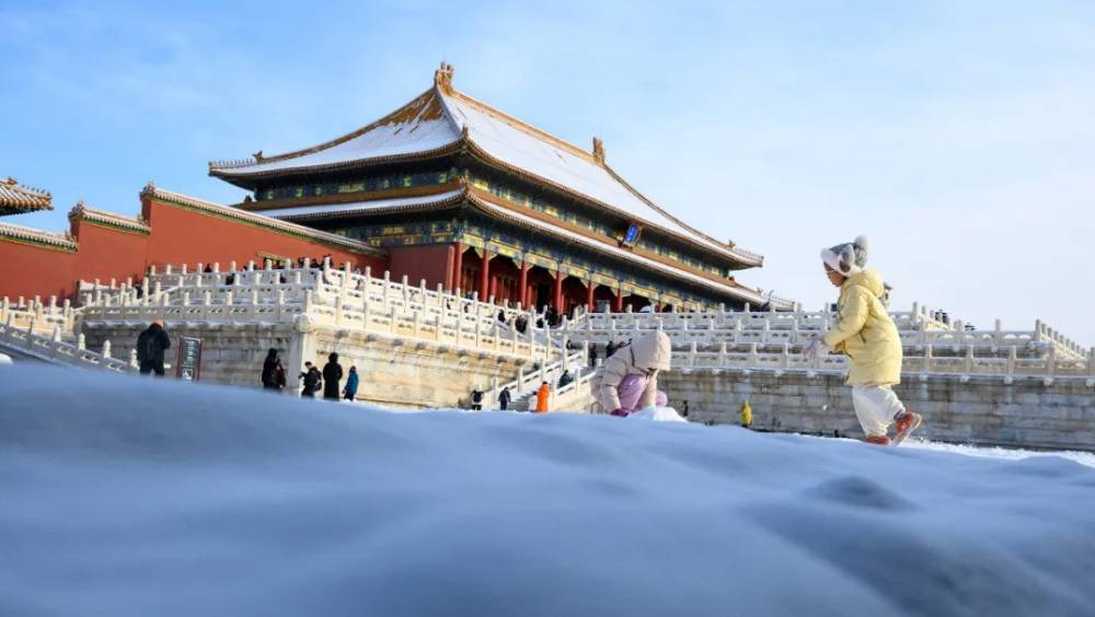 2025年12月13日，小朋友在故宮太和殿前玩雪。新華社