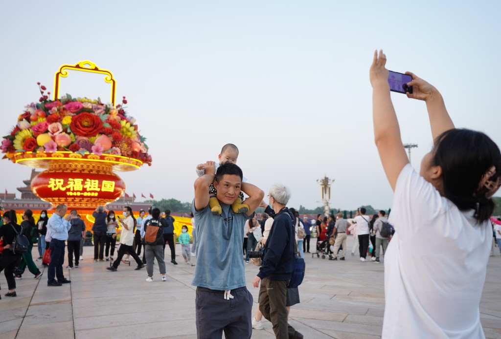 遊客在「祝福祖國」巨型花果籃前拍照留影。 新華社圖片