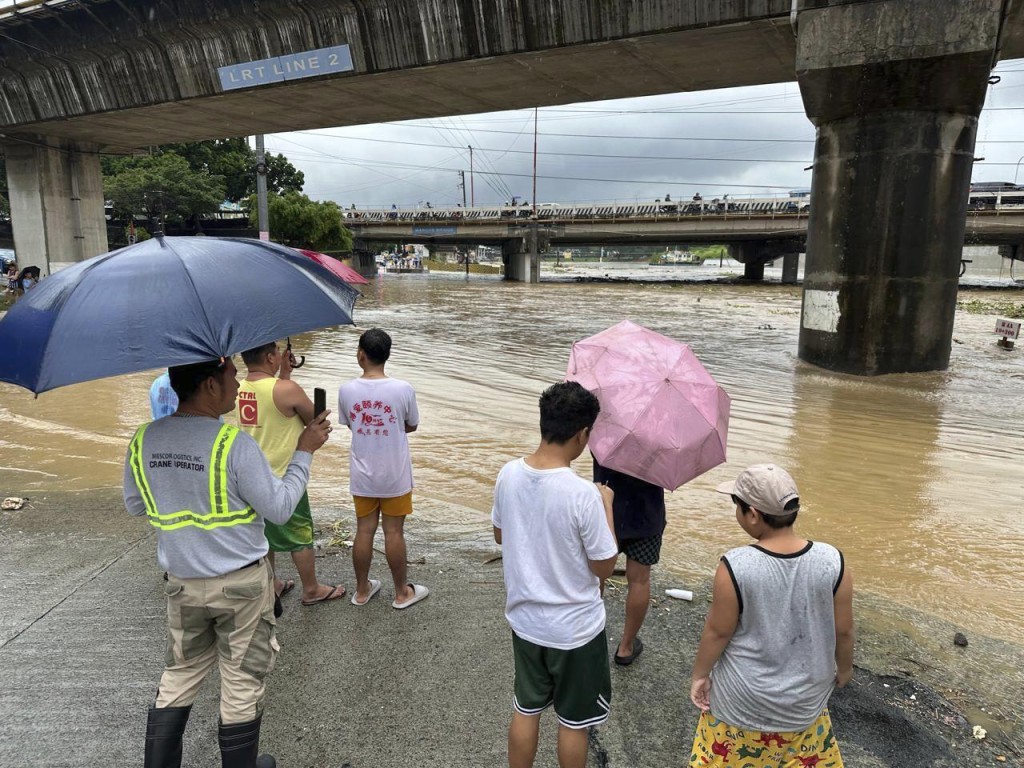 居民看着马里基纳河因近台风格美加剧降雨而泛滥。 美联社