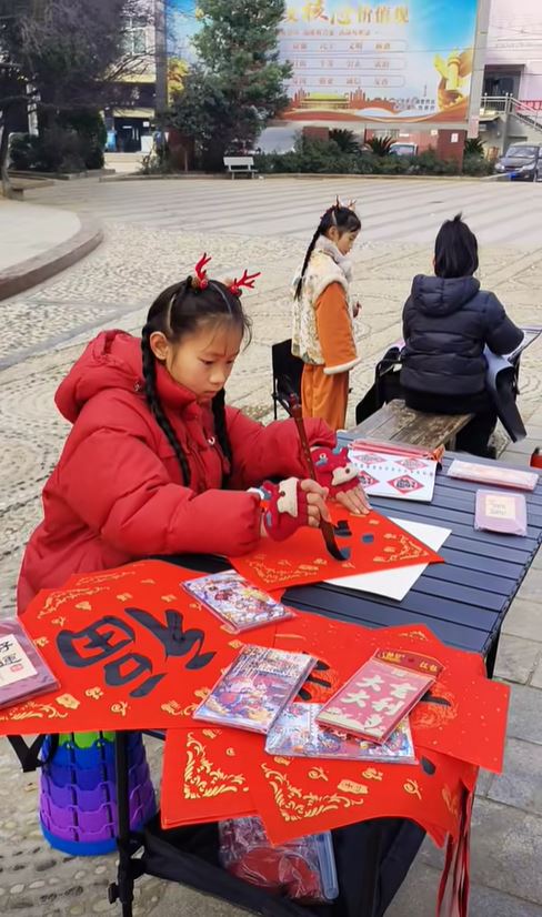 湖北11歲蔣夢涵當街賣手寫春聯，賺錢之餘又可練膽克服「社恐」。