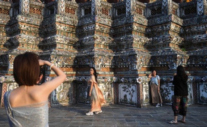 身穿泰国传统服饰的中国游客在曼谷一间佛庙内参观及拍照。路透社