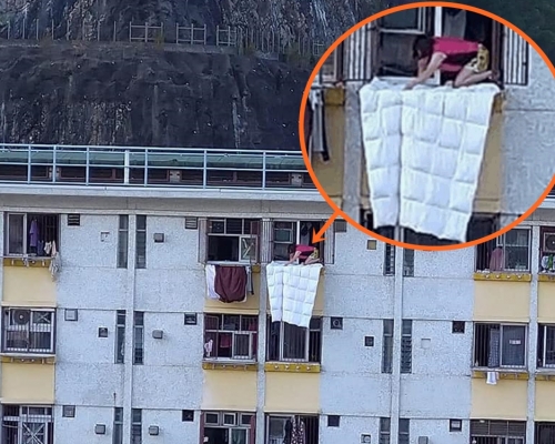 公屋頂樓女住戶爬出窗晾棉被。PLAY HARD 玩硬FB圖片