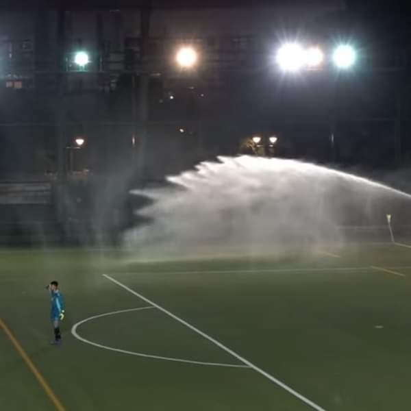 球场在黄昏6时准时洒水保养，直至十二码结束仍在洒水。网上图片