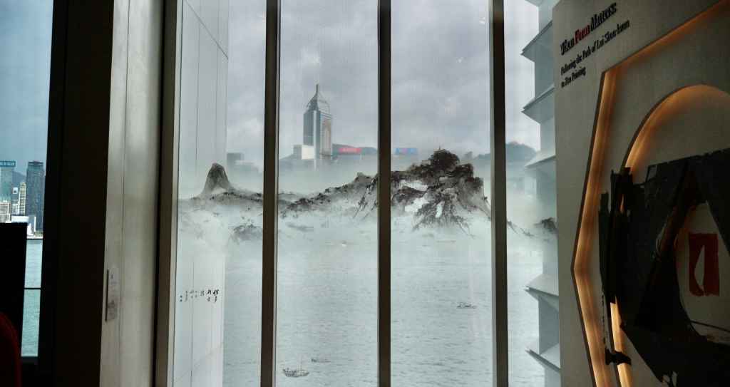 二樓香港藝術廳外，窗上貼了呂壽琨所畫山水水墨圖像，跟海港以至對岸高樓大廈景色重疊，構成異趣。
