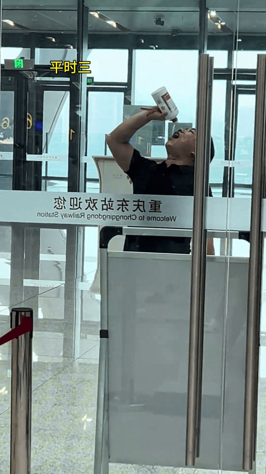 男乘客在安檢旁一口接一口的將整瓶茅台喝了。