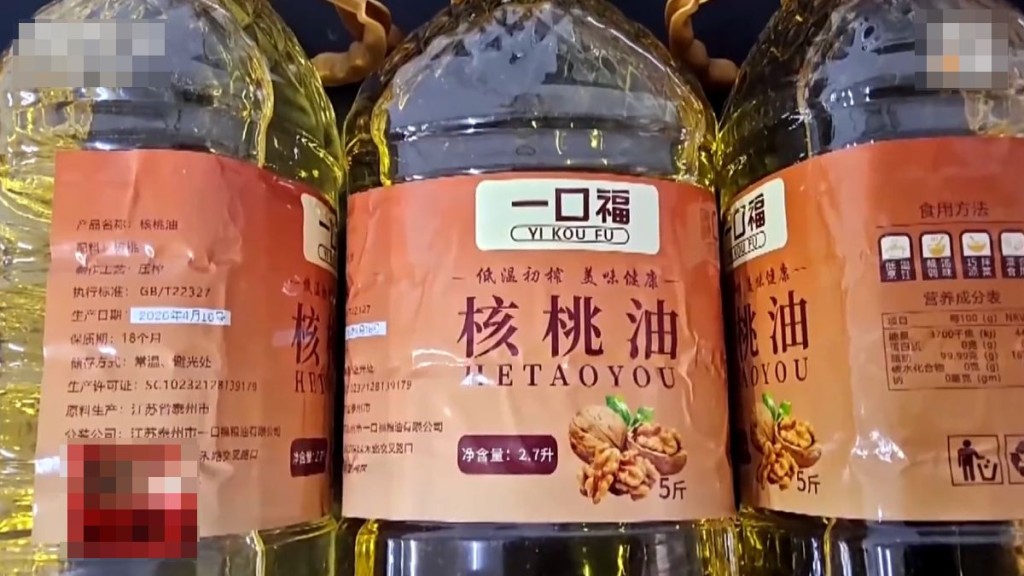 执法人员揭露该款核桃油用大豆油冒充。央视截图