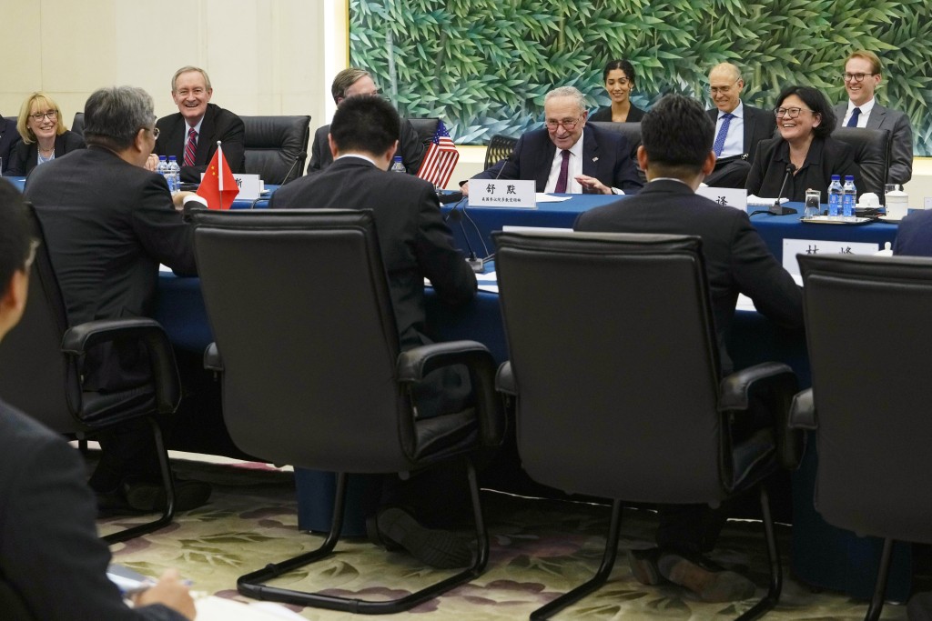 舒默（中）在北京商务部与中国商务部部长王文涛（左）举行双边会议期间分享了轻松时刻。AP