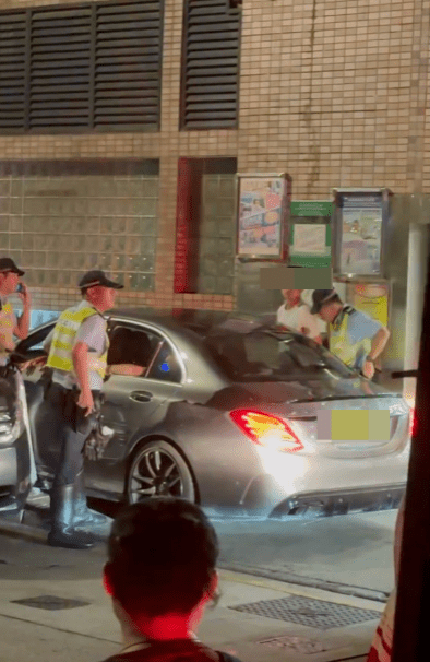 警方截停可疑Benz後,至少三名警員把Benz包圍,一名年約20多歲、穿白色短袖T恤的男子被鎖上手扣。 警方截停可疑Benz後,至少三名警員把Benz包圍,一名年約20多歲、穿白色短袖T恤的男子被鎖上手扣。
