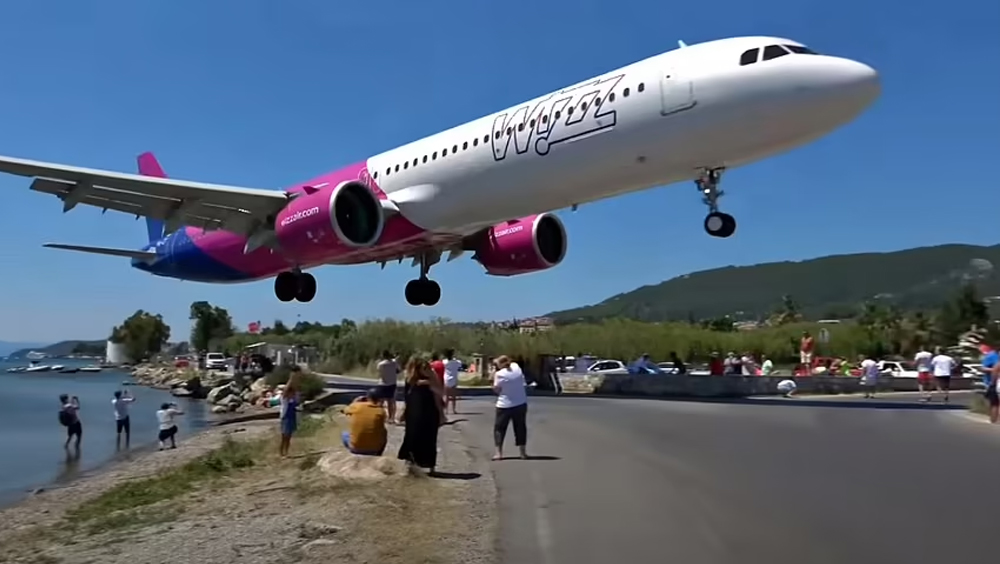 客機降落貼地飛行,頭頂飛過遊客。
