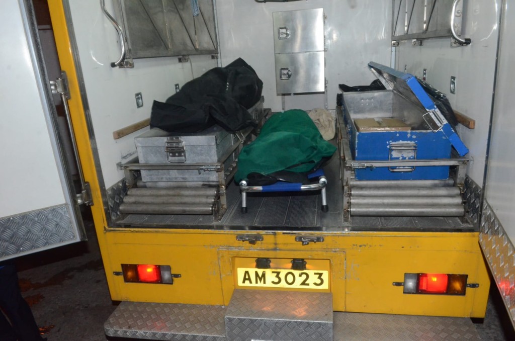 仵工移走死者遺體。