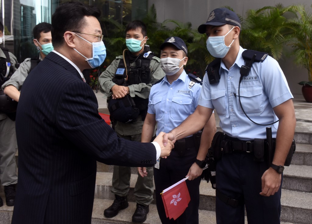 謝鋒擔任外交部駐香港特派員公署特派員時在國慶昇旗禮上與警員握手。中新社