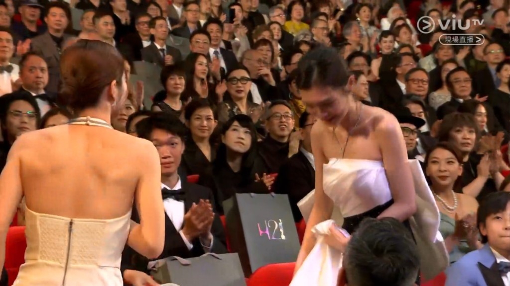 謝咏欣身穿白色低胸裙上台領獎。
