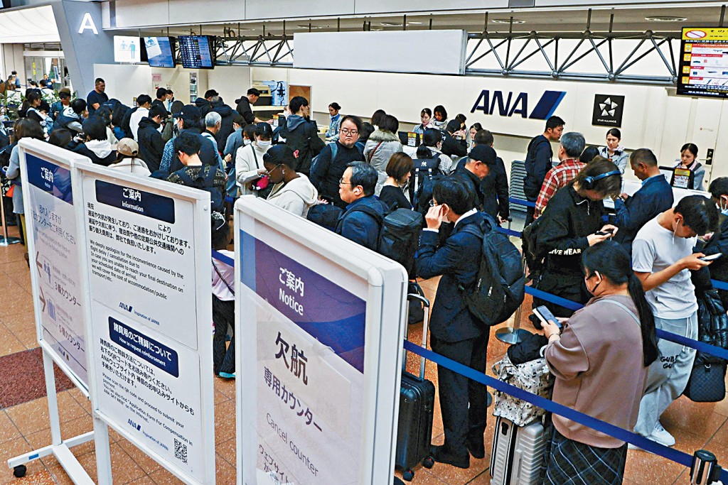 受空巴A320停飛影響，東京都羽田機場昨日有大批旅客在航空公司櫃枱前大排長龍，等待辦理後續手續。 