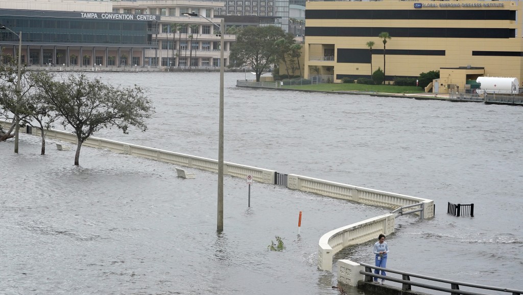 飓风「伊达利亚」带来的水将淹过海堤，一名女子在老坦帕湾海湾大道上调查水浸情况。 美联社