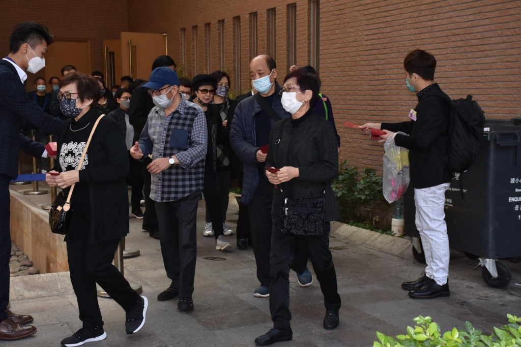 出席儀式人士在禮堂門外收下陸永昌代表派發的利是才離開。