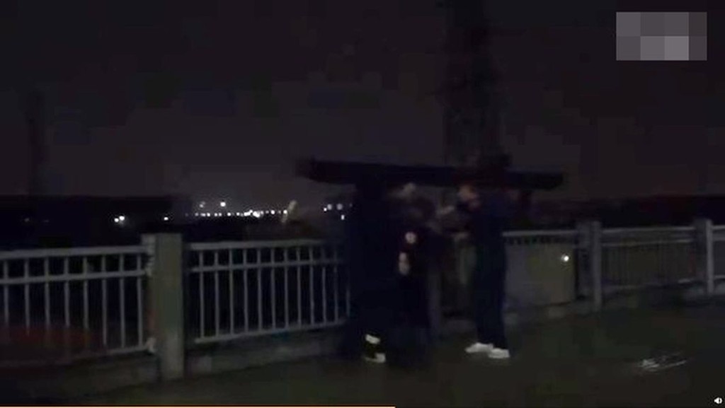 消防人員趁少女不為意時將其抱住並拉回路邊。 網圖