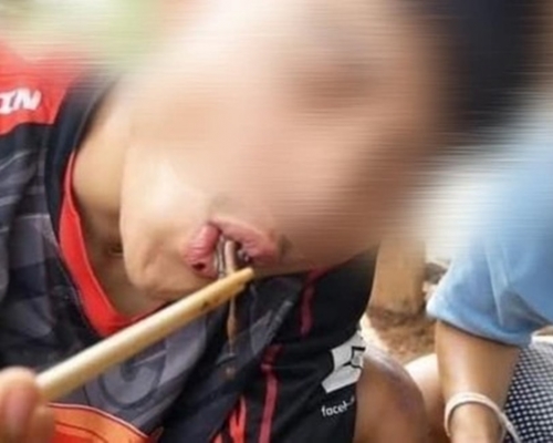 男子將蚯蚓夾起,大口大口地進食。網圖