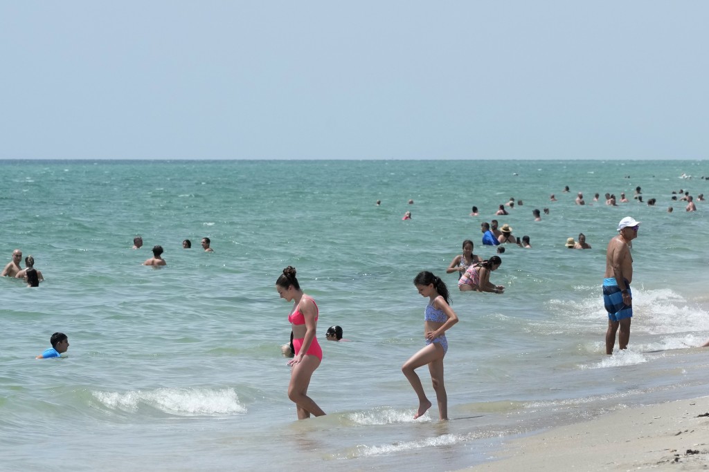 在佛羅里達州，市民到海邊游泳消暑。 美聯社