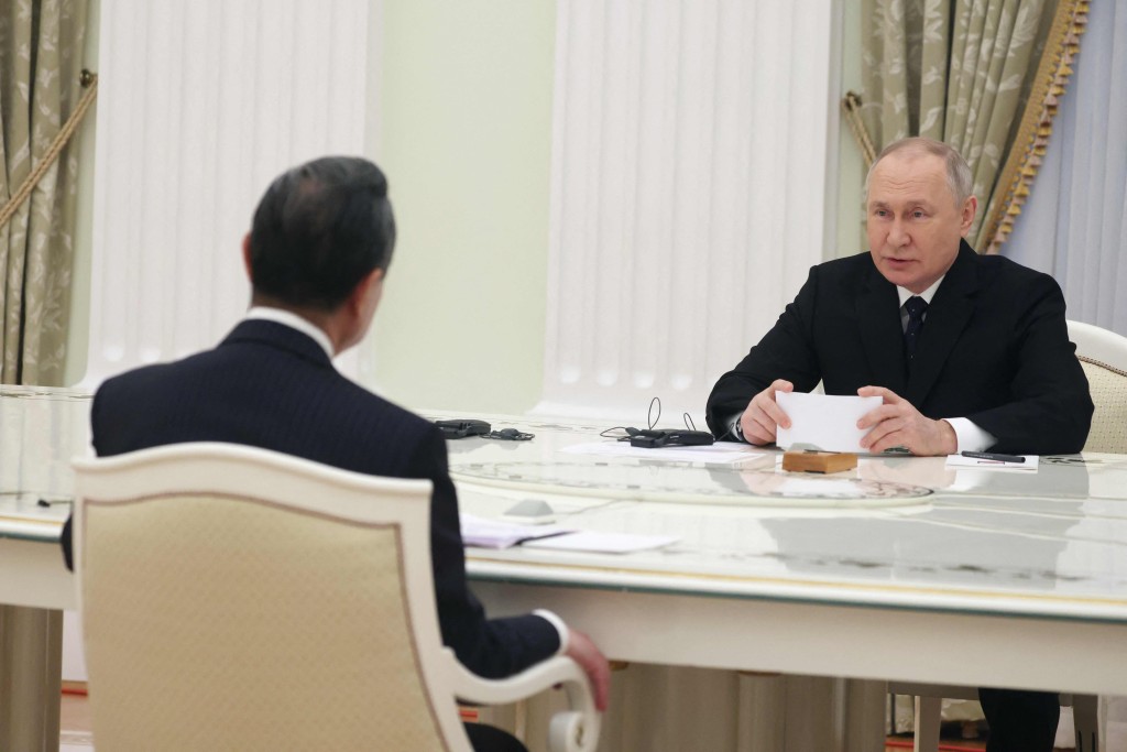 普京和王毅在长桌中间相对而坐。