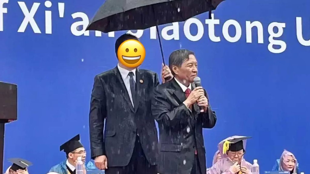 西安交通大学校长王树国致辞时突降大雨，一位神秘人突现身为王撑伞。