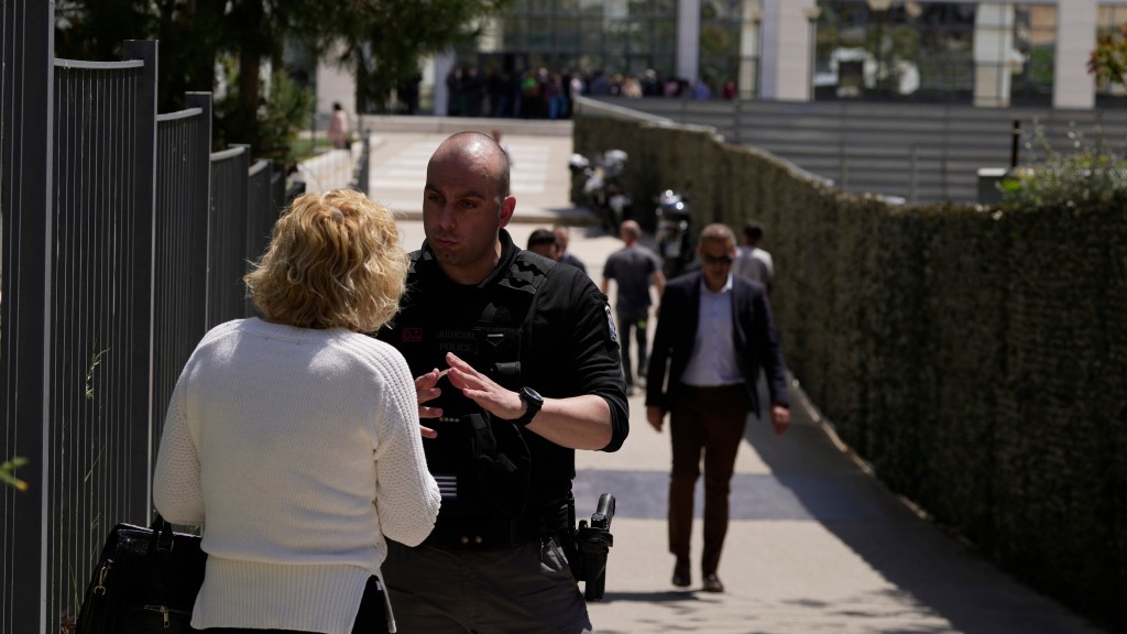 希臘法院發生槍擊案，疏散民眾向警員查詢。 美聯社