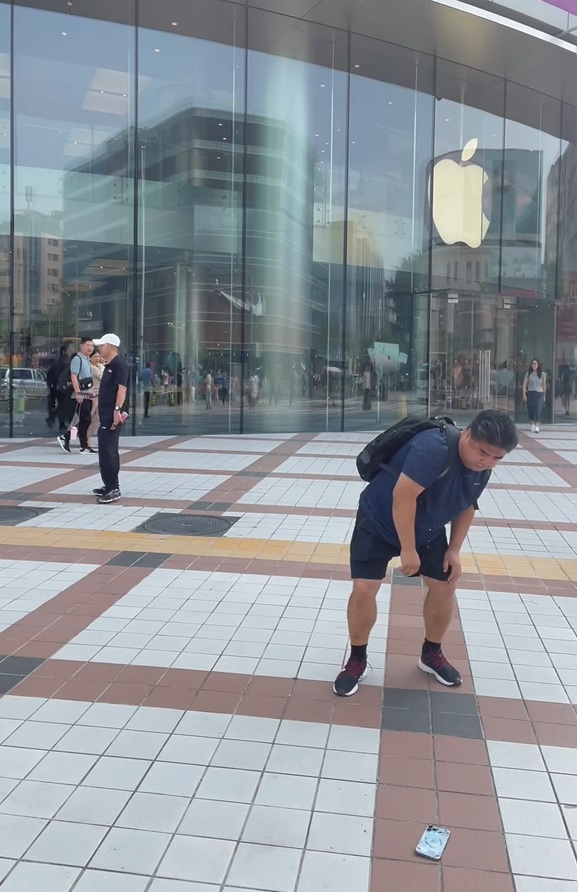 劉金在蘋果店外反覆把其iPhone擲落地。影片截圖