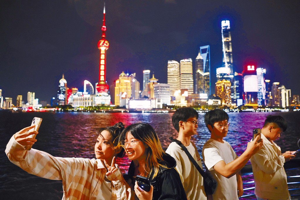 國慶期間，遊客在上海外灘濱江步道上合影。