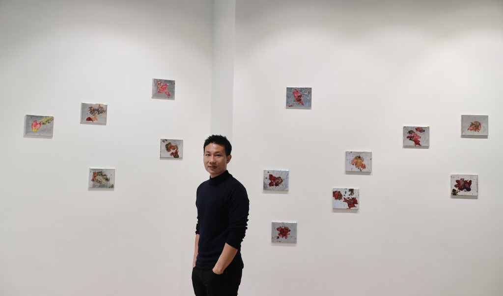 鄭哈雷站在展場一幅牆壁前，其起伏不定的畫作，如他展開了的翅膀。