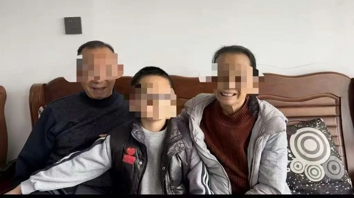 小毅（化名）与祖父母合照。