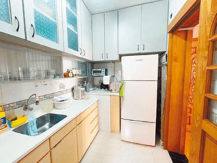 廚房設有齊全家電配備，L 形工作台提供充足空間擺放各式家電。