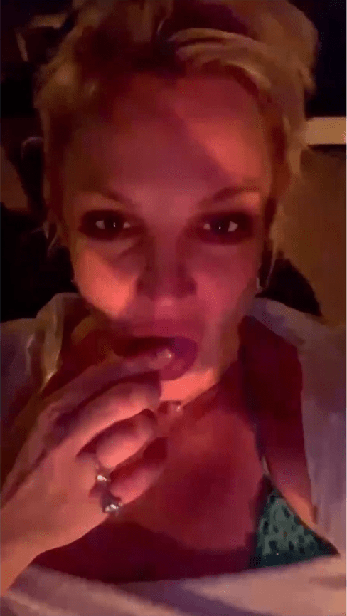 Britney Spears用食指舔上口水。