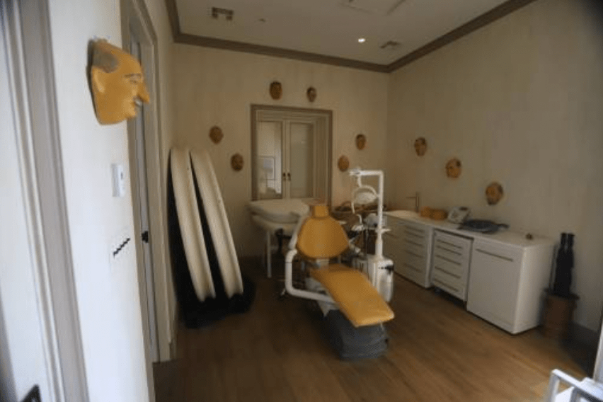 其中一張照片引起極大關注——一張類似牙科治療椅的座椅陳列在陰暗房間中央，牆上掛着多幅男性面孔或面具，氣氛詭異。法新社